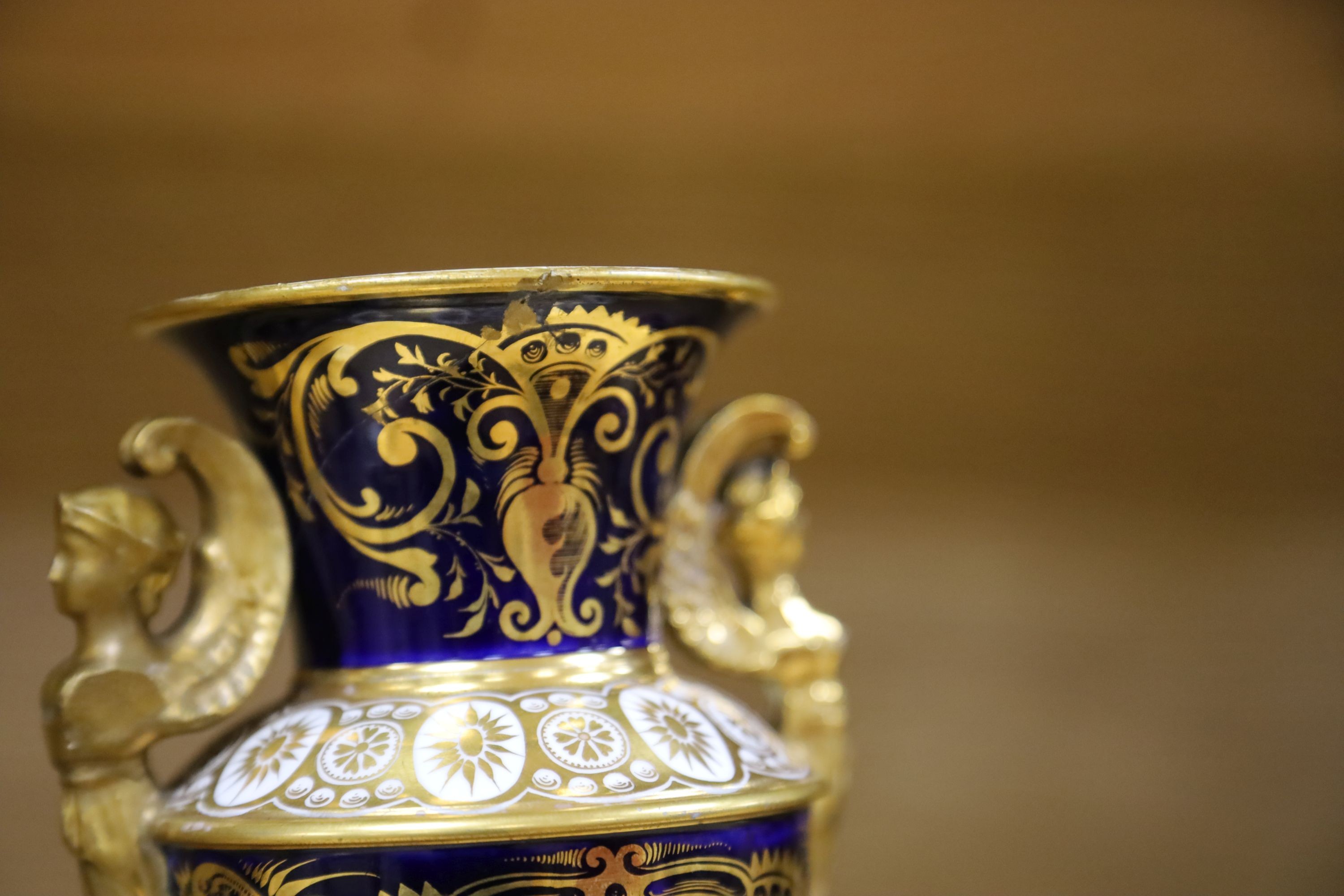 A garniture of three early 19th century English porcelain vases, c.1815-20, each painted with topographical views, tallest 26cm